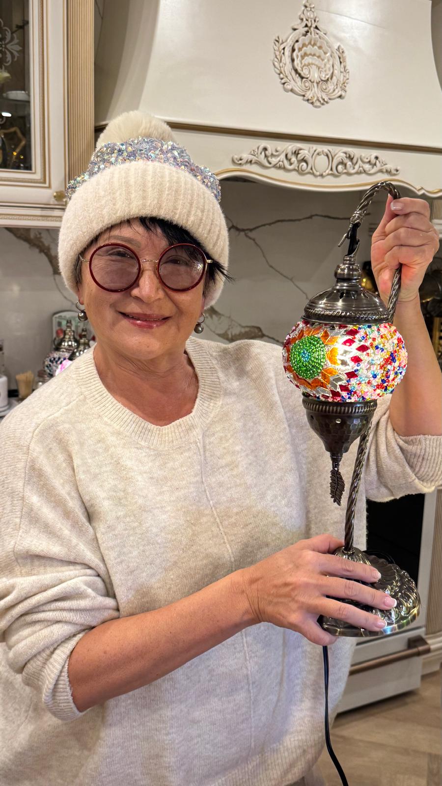 Nadia proudly holding her Emerald Spiral swan neck lamp